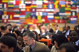 Conference participants in front of flags of many countries 