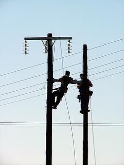 Zwei Arbeiter auf zwei Leitungsmasten - let's connect!